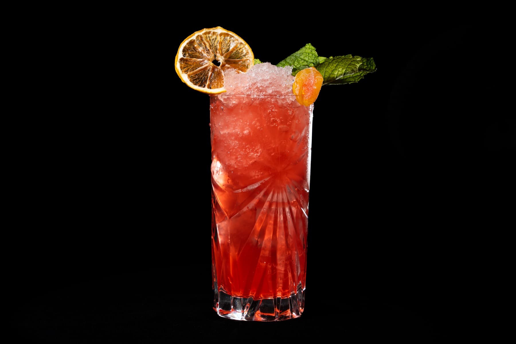 A tall Kasai signature cocktail finished with a dried lemon wheel and mint