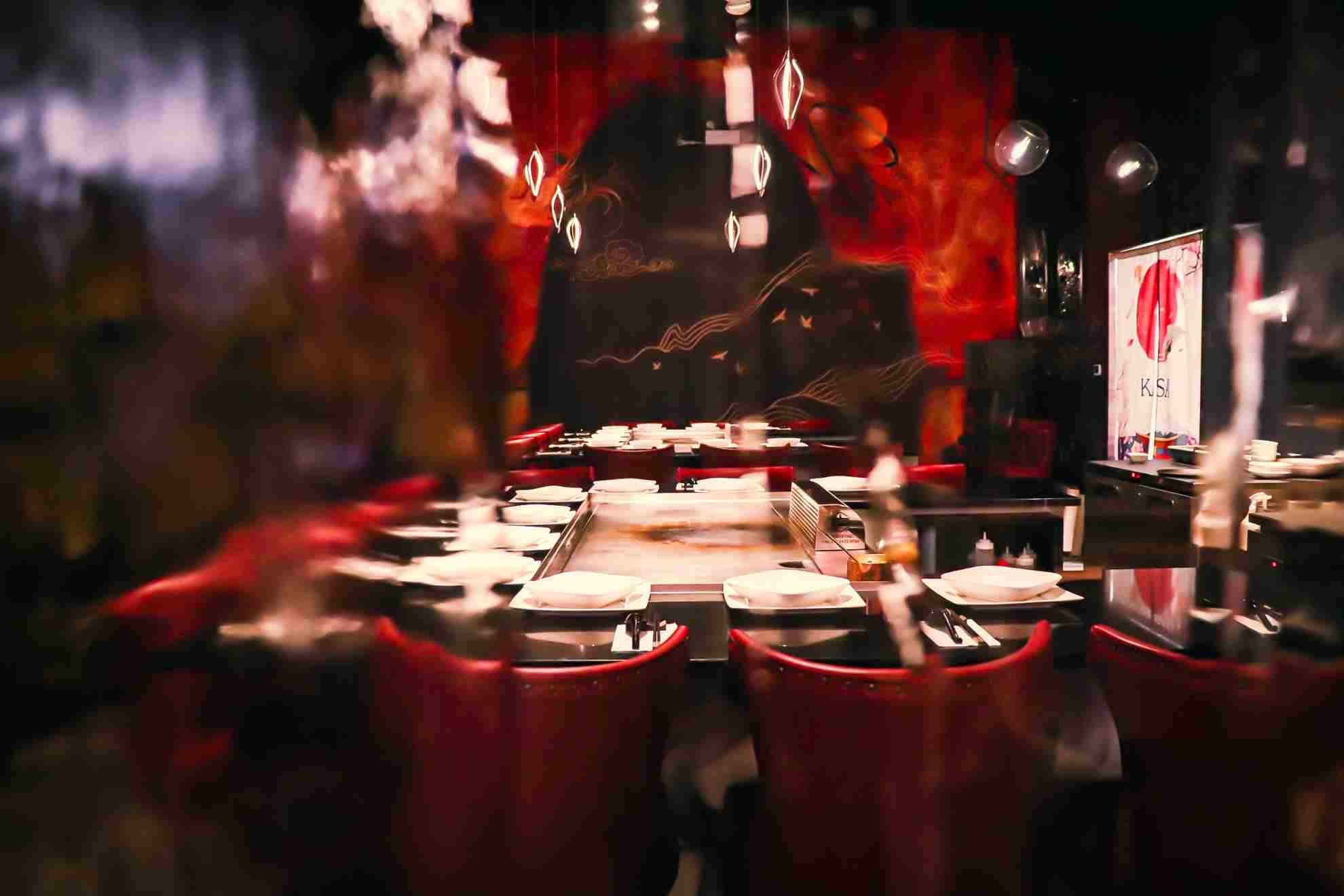 Kasai's dining room — red leather chairs around a teppanyaki grill against a hand-painted mural