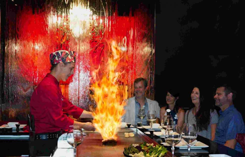 A Kasai chef cooking over open flame for a table of guests